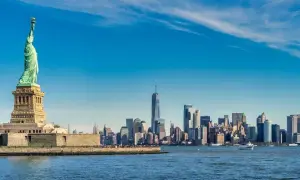 Statua Wolności i panorama Manhattanu nad wodą.