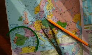 Mapa Europy z ołówkiem, cyrklem i linijką, sugerująca planowanie podróży.