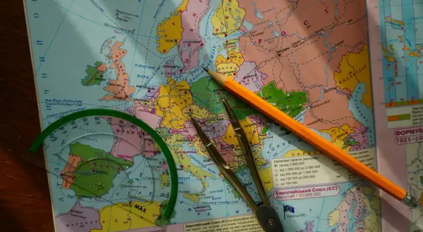 Mapa Europy z ołówkiem, cyrklem i linijką, sugerująca planowanie podróży.