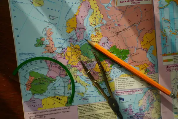 Mapa Europy z ołówkiem, cyrklem i linijką, sugerująca planowanie podróży.